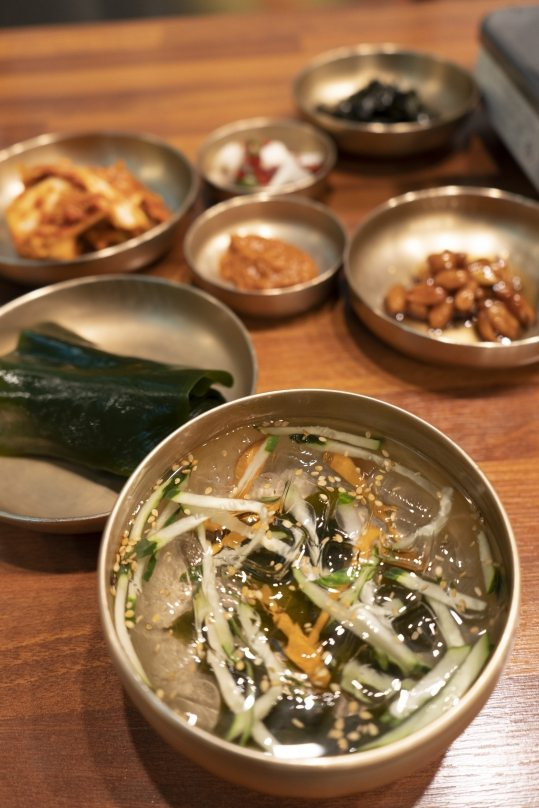 놋그릇 반찬(김치·쌈장·땅콩조림·다시마·김가루·양파고추)과 앞쪽 오이·미역 냉국